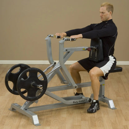 A person using the Body-Solid Pro ClubLine Leverage Seated Row Machine LVSR, demonstrating proper form while seated and pulling the handles towards them with weights on the machine.