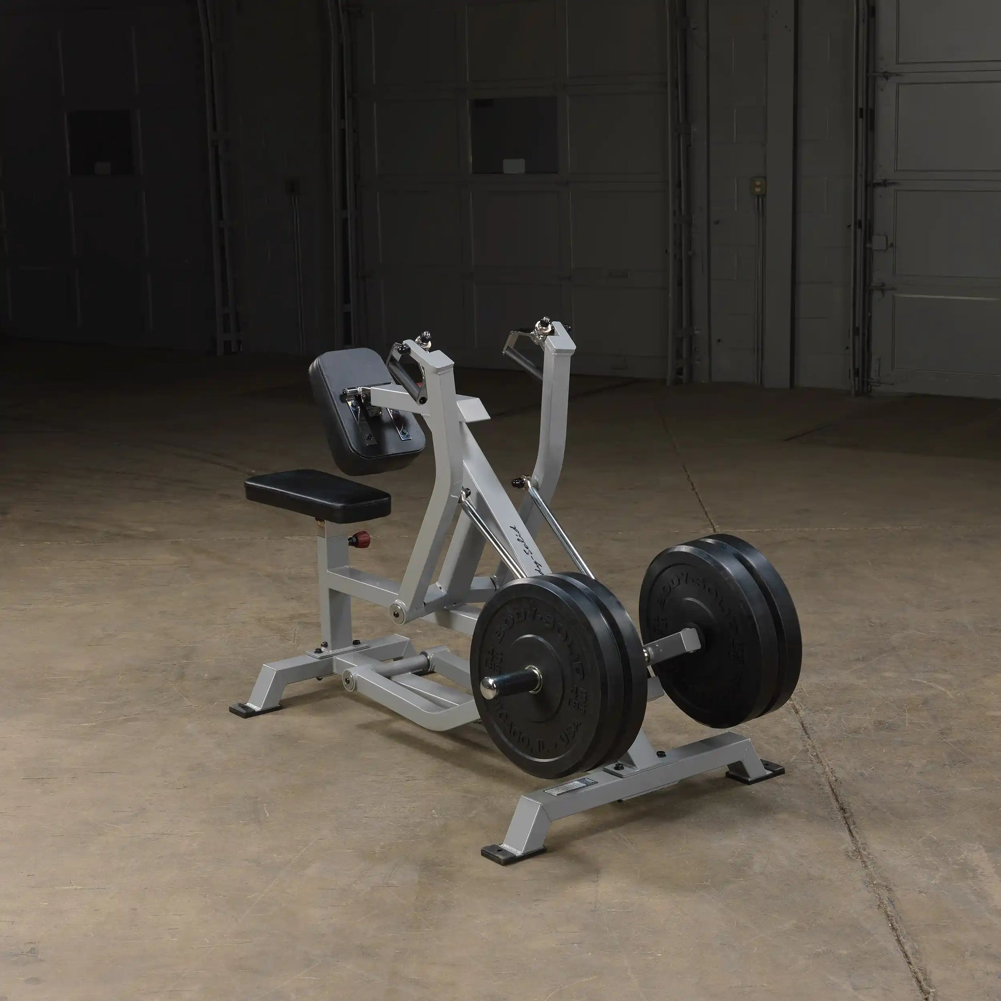 Body-Solid Pro ClubLine Leverage Seated Row Machine LVSR positioned on a gym floor, featuring a padded seat and adjustable arm handles, with weight plates attached for resistance.
