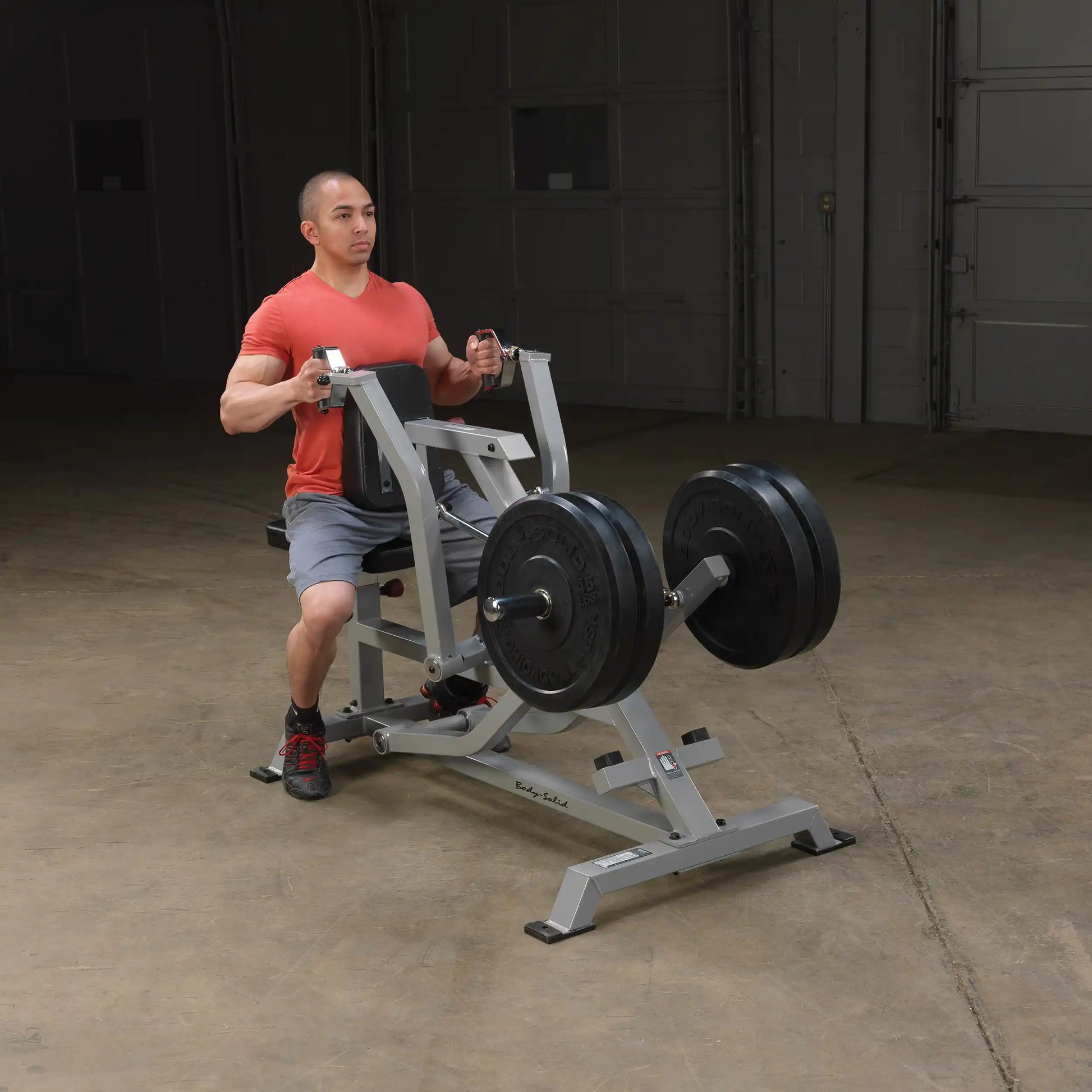 A person using the Body-Solid Pro ClubLine Leverage Seated Row Machine LVSR in a gym setting, demonstrating proper form while performing a seated row exercise.