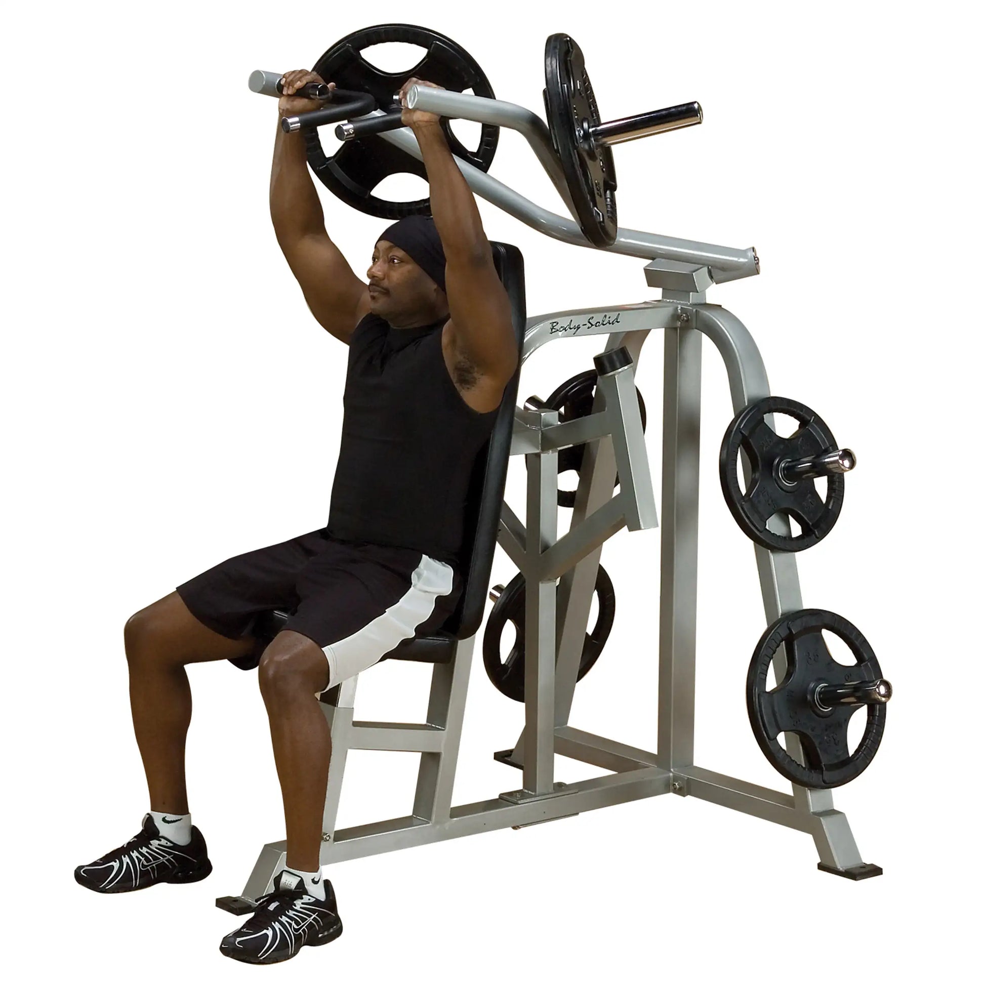 A man demonstrating the Body-Solid Pro ClubLine Leverage Shoulder Press Machine LVSP, seated and lifting weights overhead.
