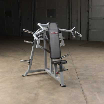 Body-Solid Pro ClubLine Leverage Shoulder Press Machine LVSP positioned in a spacious gym setting with a concrete floor and garage-style background.
