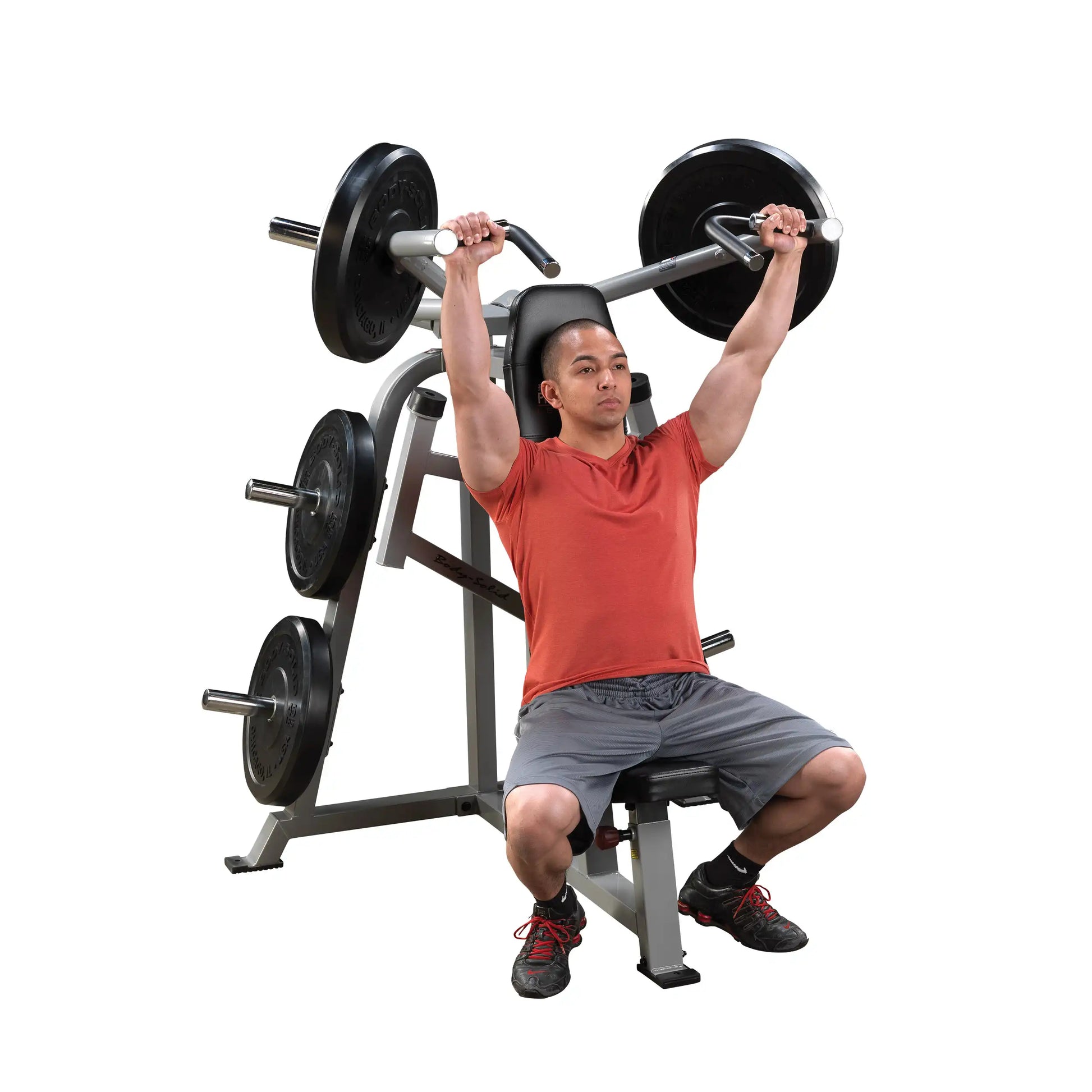 A person using the Body-Solid Pro ClubLine Leverage Shoulder Press Machine LVSP, performing an overhead shoulder press with weights.