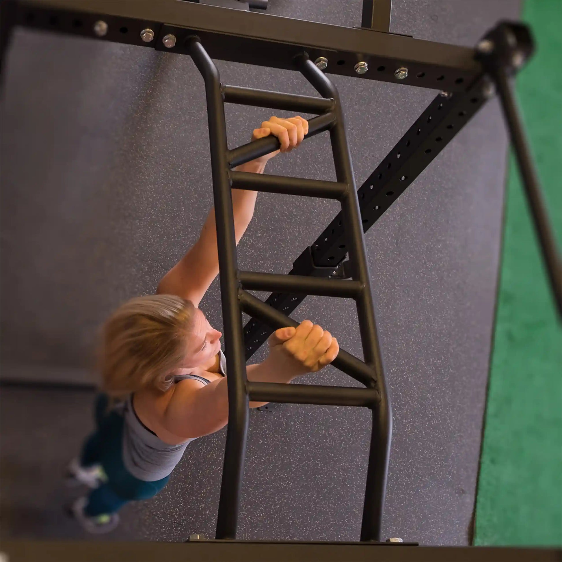Aerial view of a person using the Body-Solid Pro ClubLine Multi Chin-Up Attachment SPRCUA, gripping the multi chin-up bar in a fitness setting.