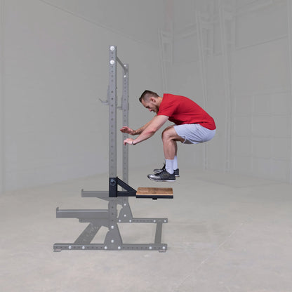 A person performing a jump exercise on the Body-Solid Pro ClubLine Plyo Step Attachment SPRSTEP, showcasing the equipment's use in a fitness setting.
