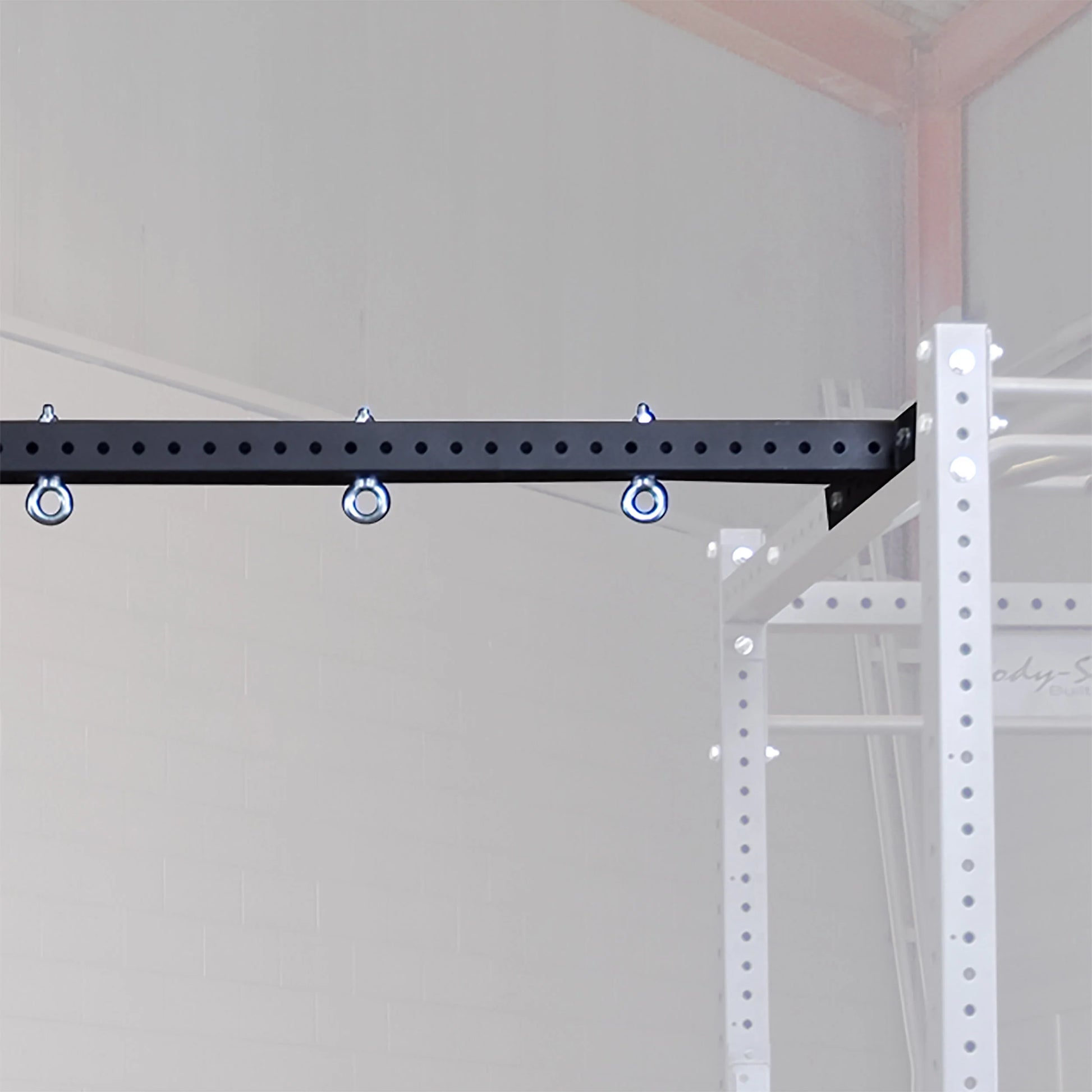 Body-Solid Pro ClubLine Power Rack Connecting Bar SPRACB attached to a white power rack frame, featuring multiple anchor points for added versatility.