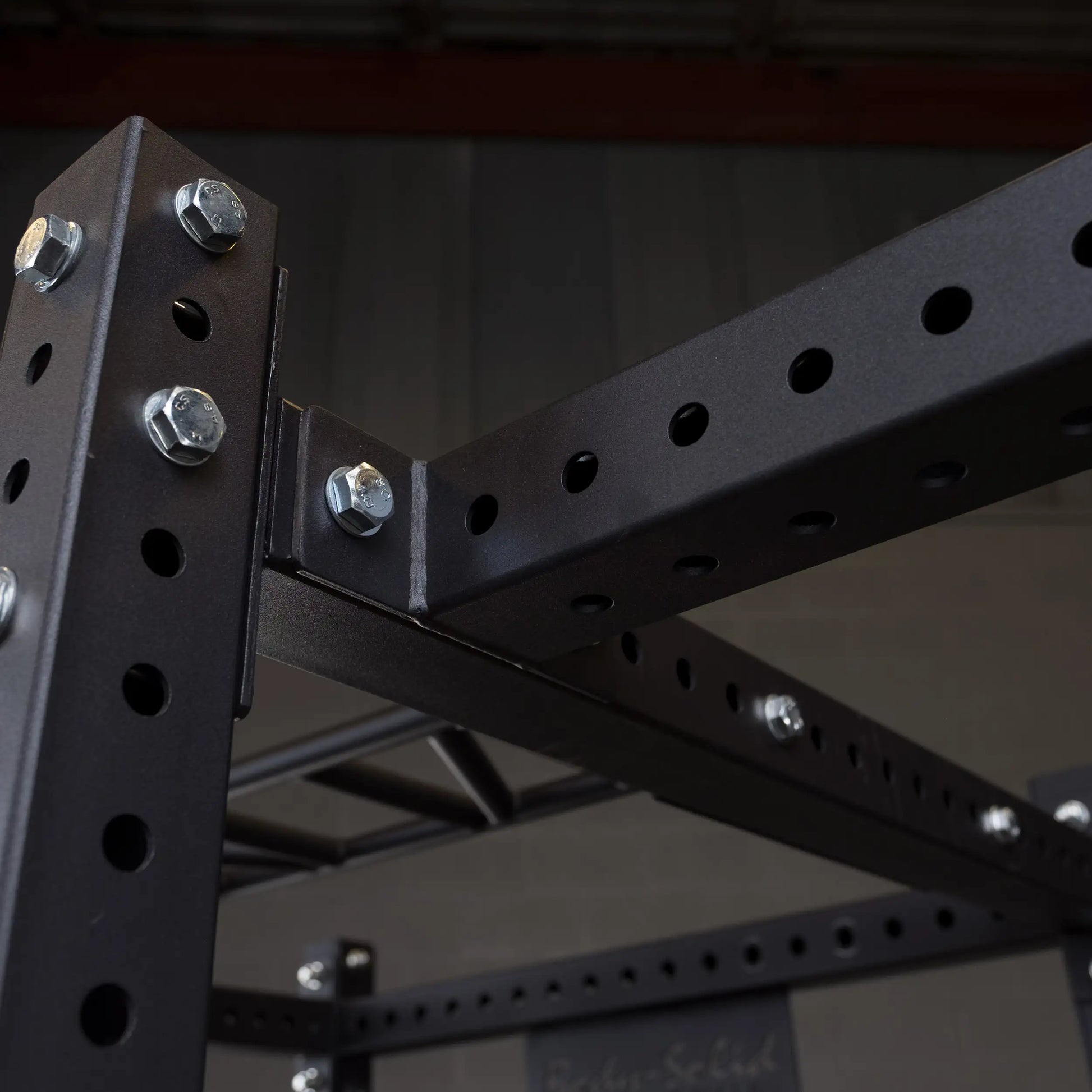 Close-up view of the Body-Solid Pro ClubLine Power Rack Connecting Bar SPRACB, showcasing its sturdy, perforated metal design and bolted construction.