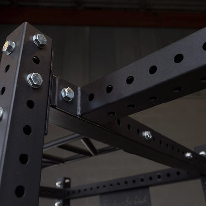 Close-up view of the Body-Solid Pro ClubLine Power Rack Connecting Bar SPRACB, showcasing its sturdy, perforated metal design and bolted construction.