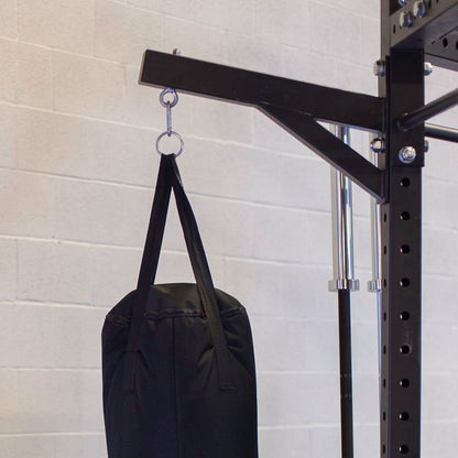 Body-Solid Pro ClubLine Power Rack Heavy Bag Hanger SPRHBH holding a black heavy bag, mounted on a sturdy rack against a light gray wall.