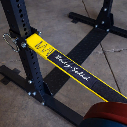Close-up of Body-Solid Pro ClubLine Power Rack Safety Straps SPRSS attached to a power rack, featuring a yellow strap with the Body-Solid logo.