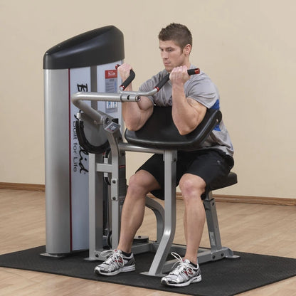 A man using the Body-Solid Pro ClubLine Series 2 Arm Curl Machine S2AC, performing an arm curl exercise in a gym setting.
