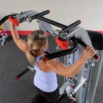 A person using the Body-Solid Pro ClubLine Series 2 Assisted Chin & Dip Machine S2ACD, demonstrating an exercise with the machine's handles.