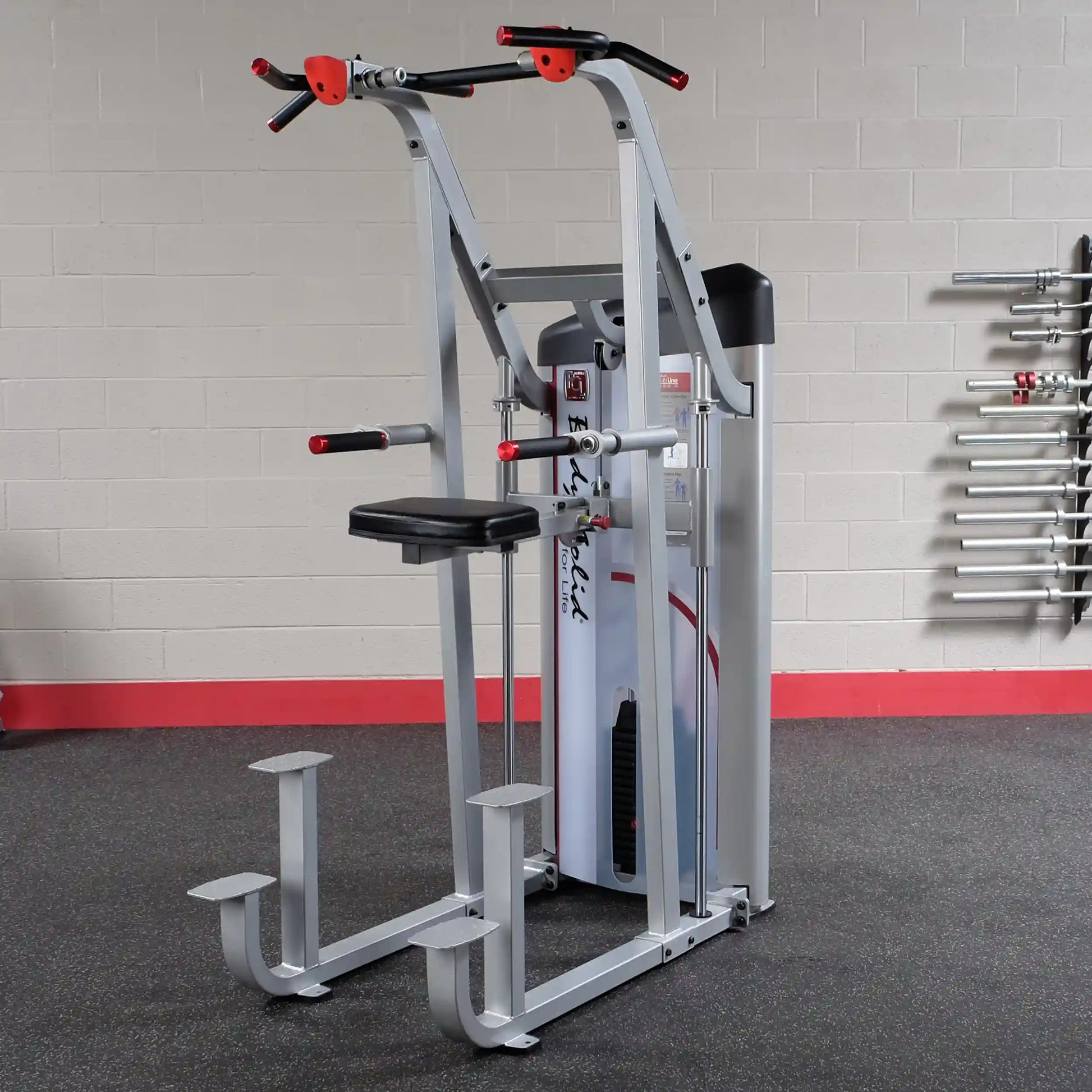 Body-Solid Pro ClubLine Series 2 Assisted Chin & Dip Machine S2ACD in a gym setting, featuring a sturdy frame with padded seat and handles for performing chin-ups and dips.