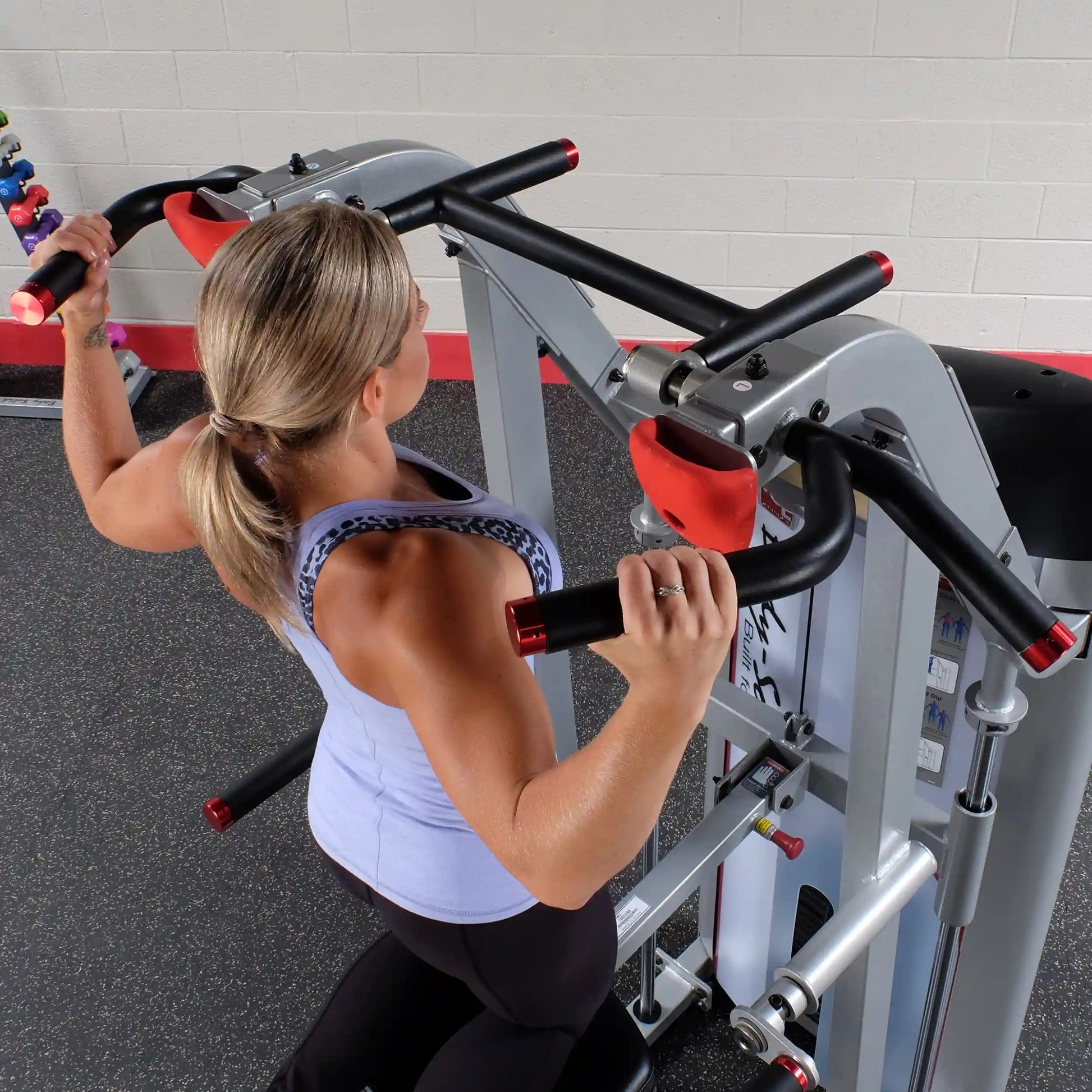 A person using the Body-Solid Pro ClubLine Series 2 Assisted Chin & Dip Machine S2ACD, performing a chin-up exercise.