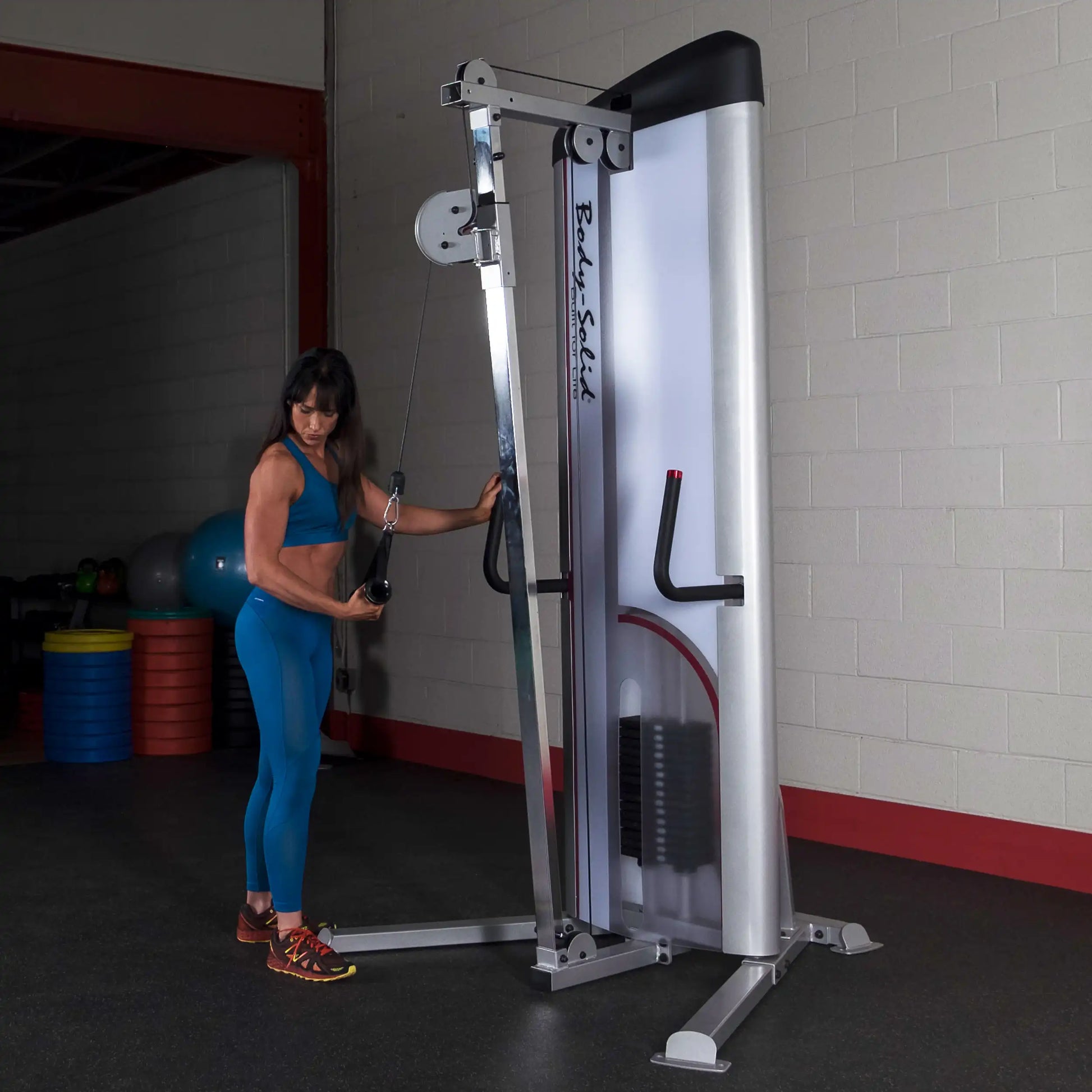 A person using the Body-Solid Pro ClubLine Series 2 Cable Column S2CC in a gym setting, performing an exercise with a cable attachment.