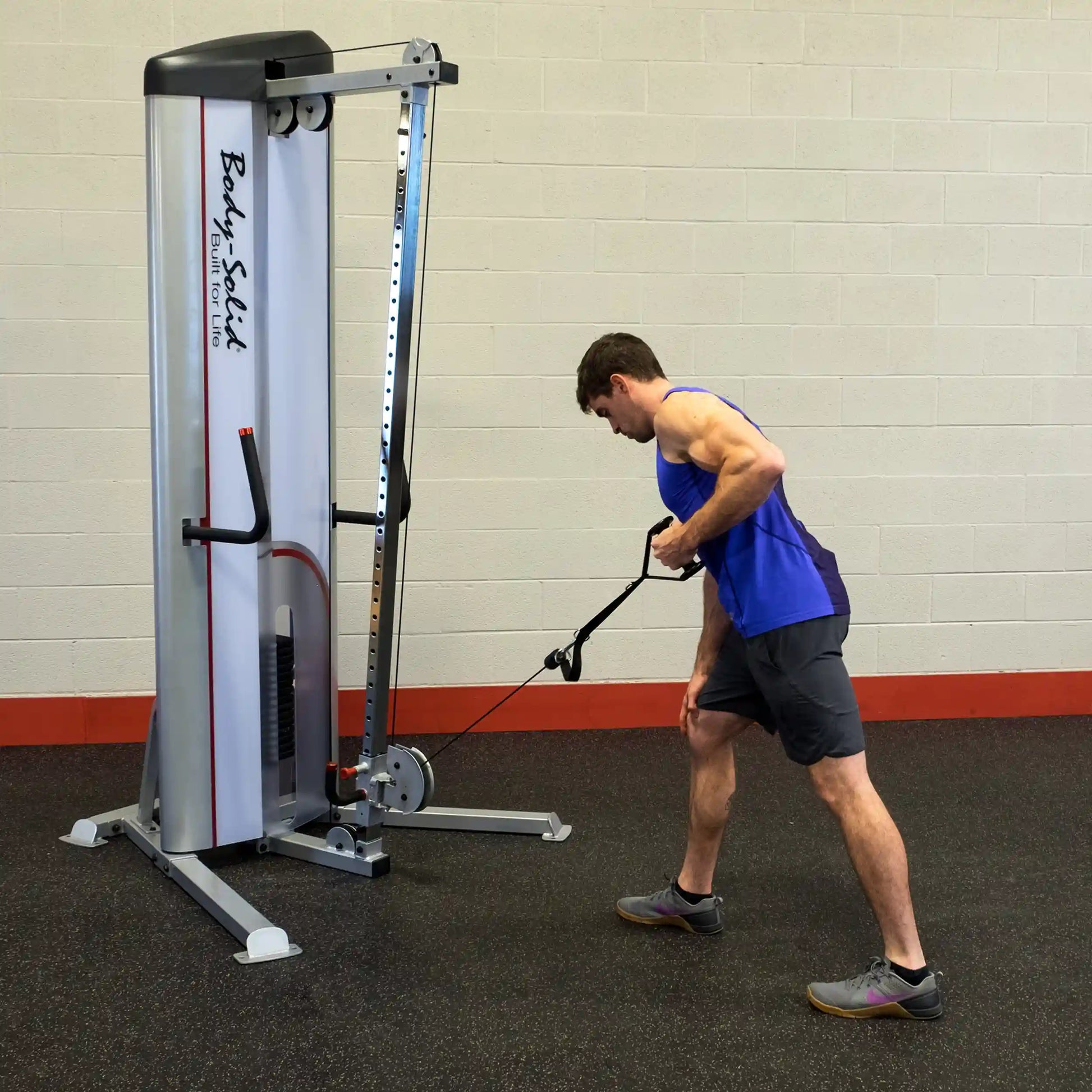 A man in a blue tank top performs a cable exercise using the Body-Solid Pro ClubLine Series 2 Cable Column S2CC in a gym setting.