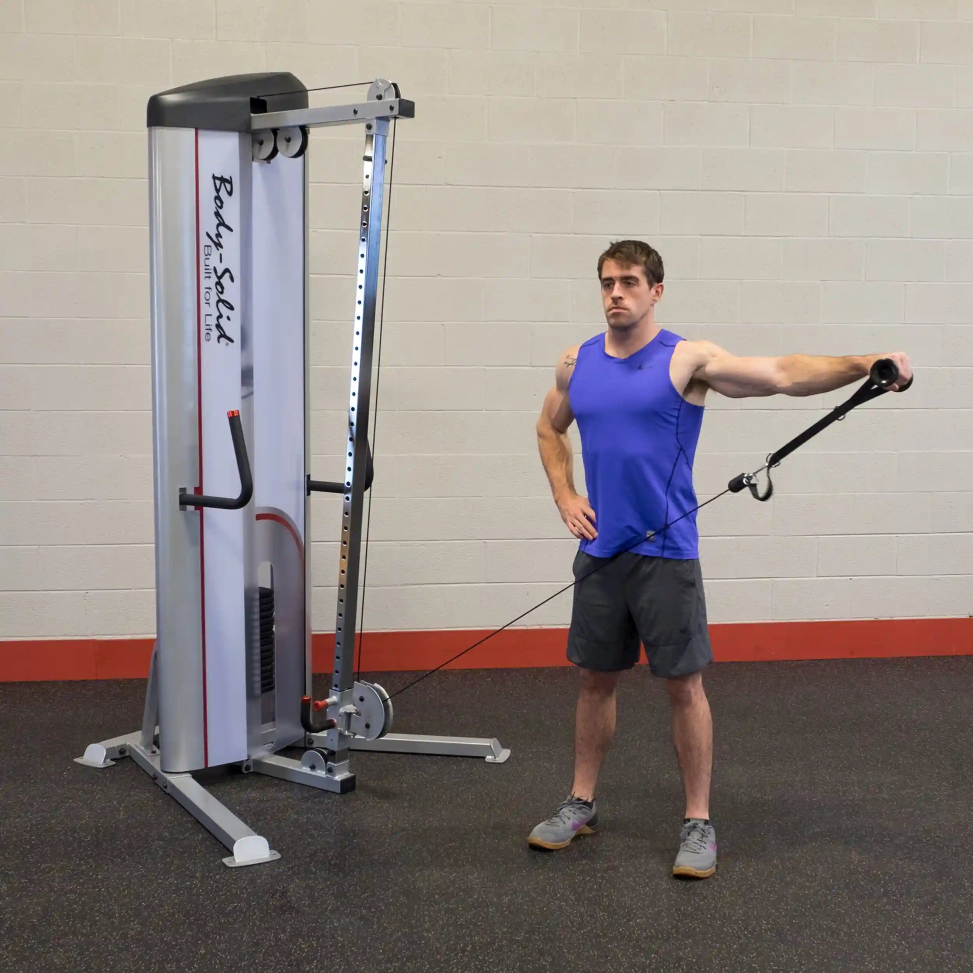 A man demonstrating an exercise using the Body-Solid Pro ClubLine Series 2 Cable Column S2CC, standing with one arm extended while holding the cable attachment.