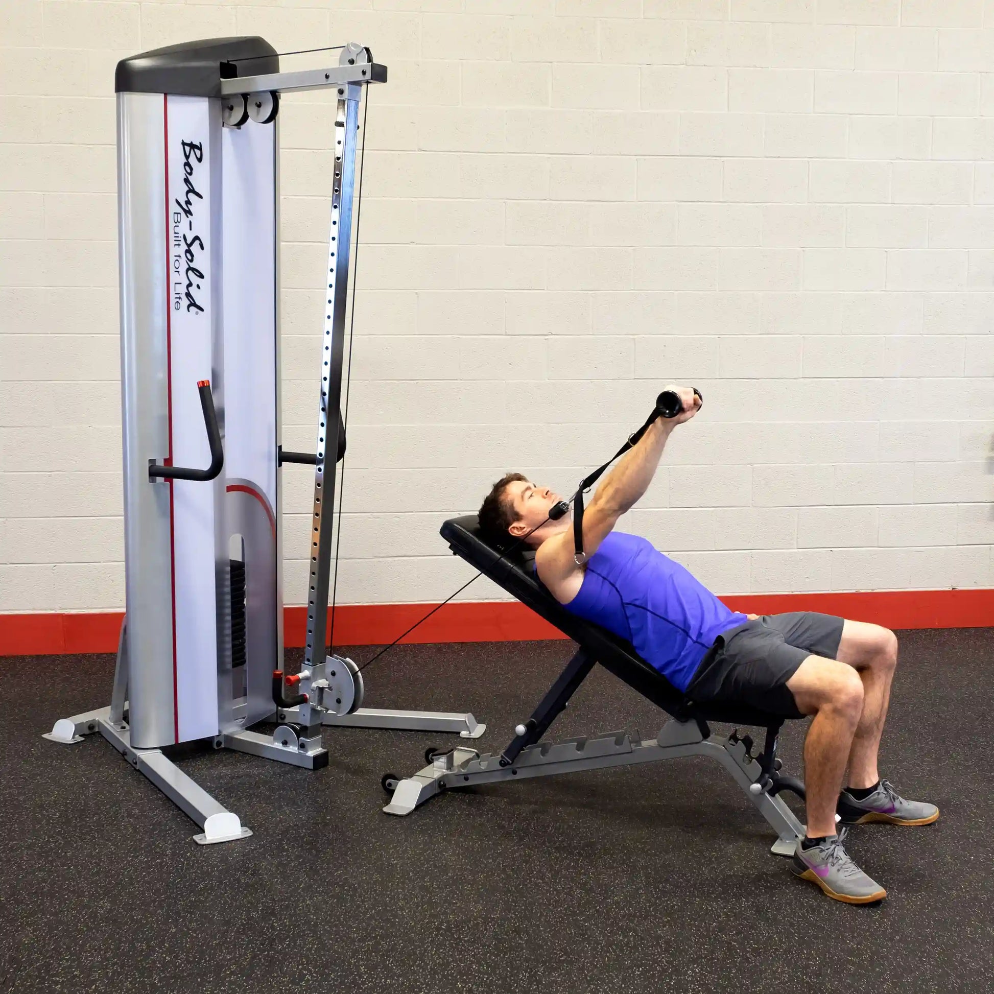 A man performing a cable exercise on a bench using the Body-Solid Pro ClubLine Series 2 Cable Column S2CC, with the cable column positioned beside him in a gym setting.