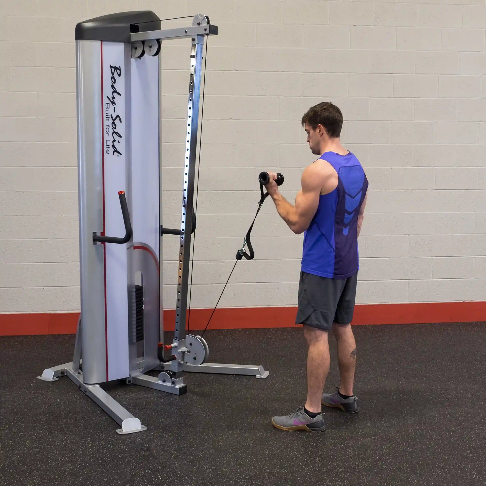 A person using the Body-Solid Pro ClubLine Series 2 Cable Column S2CC in a gym setting, performing an exercise with a cable attachment.