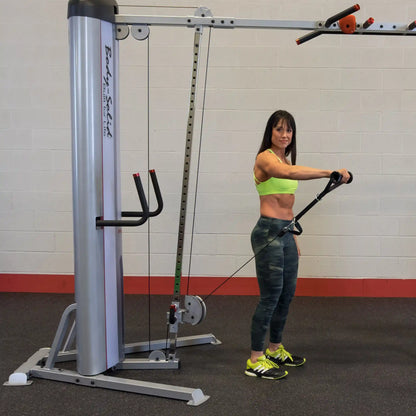 A woman performing an exercise using the Body-Solid Pro ClubLine Series 2 Cable Crossover S2CCO in a gym setting.