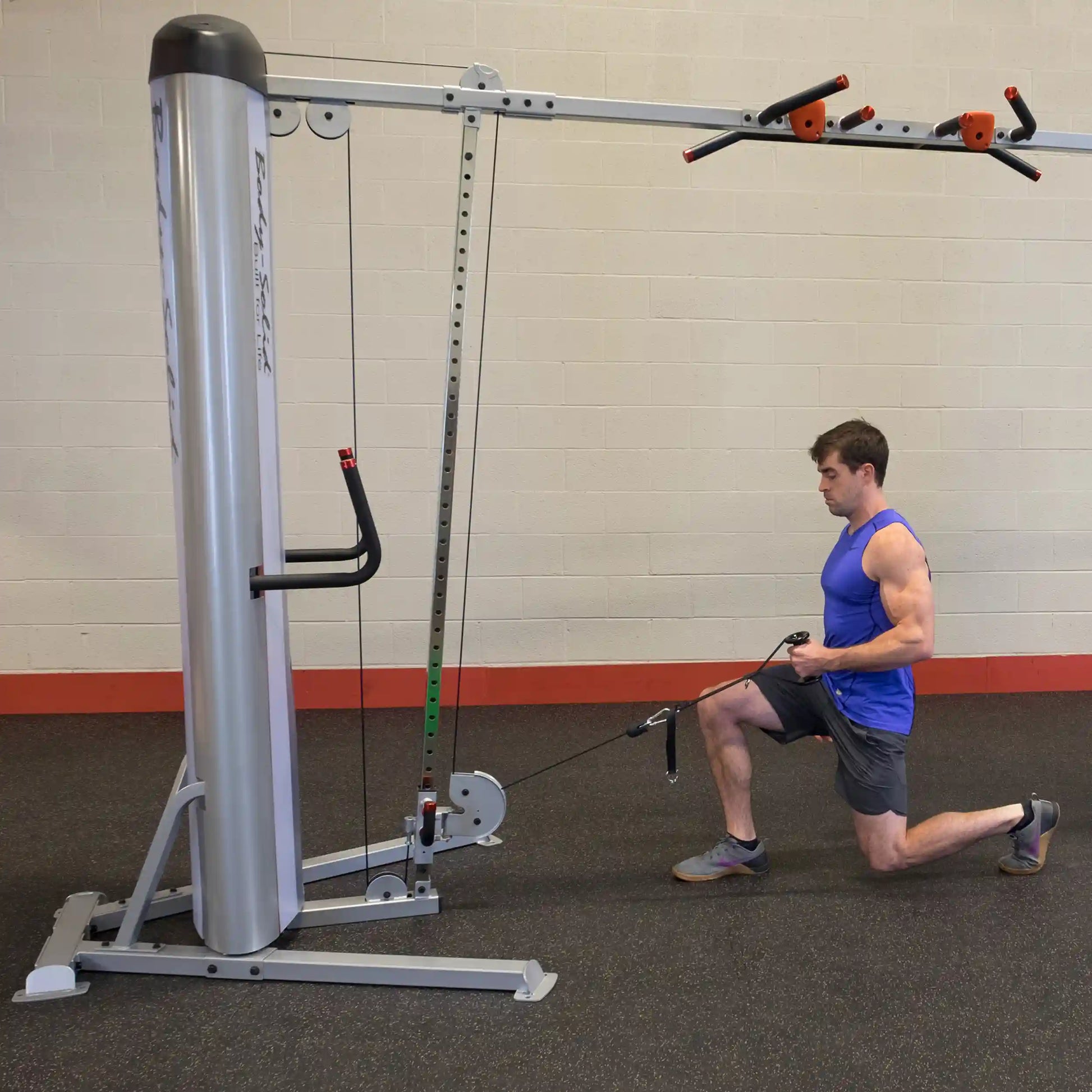A man performing an exercise on the Body-Solid Pro ClubLine Series 2 Cable Crossover S2CCO, kneeling and using the cable attachment for resistance training.