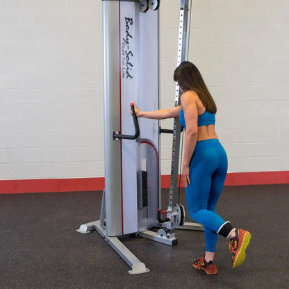 A woman in a blue workout outfit using the Body-Solid Pro ClubLine Series 2 Cable Crossover S2CCO for exercise, demonstrating proper form in a gym setting.
