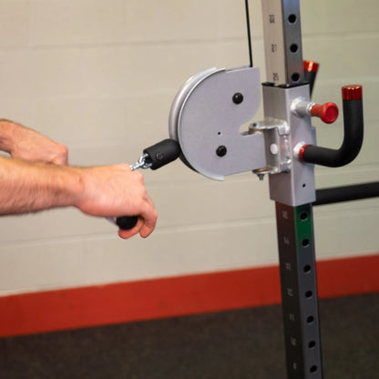 Person using the Body-Solid Pro ClubLine Series 2 Cable Crossover S2CCO with hands gripping the handles, demonstrating a workout setup.