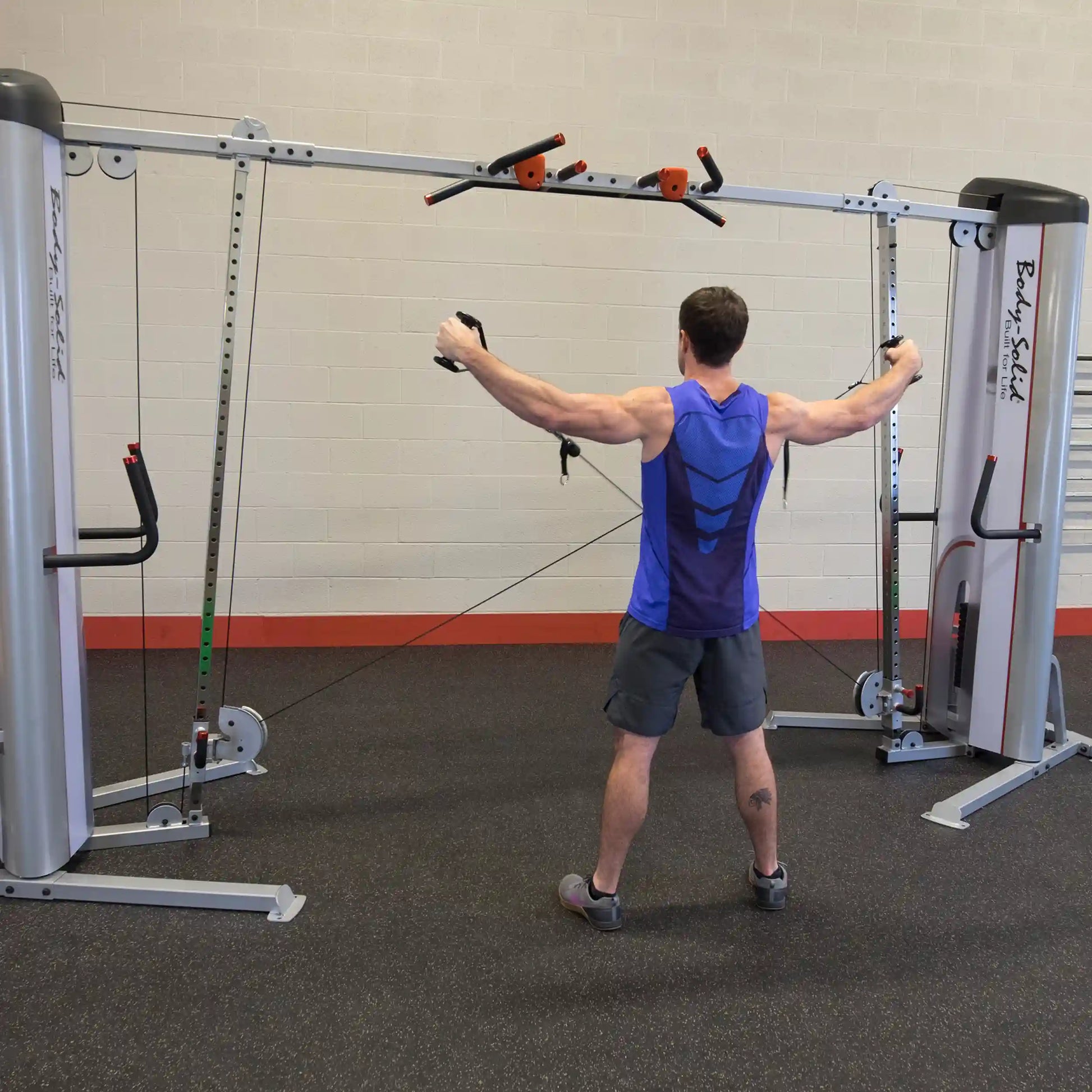 A person using the Body-Solid Pro ClubLine Series 2 Cable Crossover S2CCO, performing a cable crossover exercise in a gym setting.