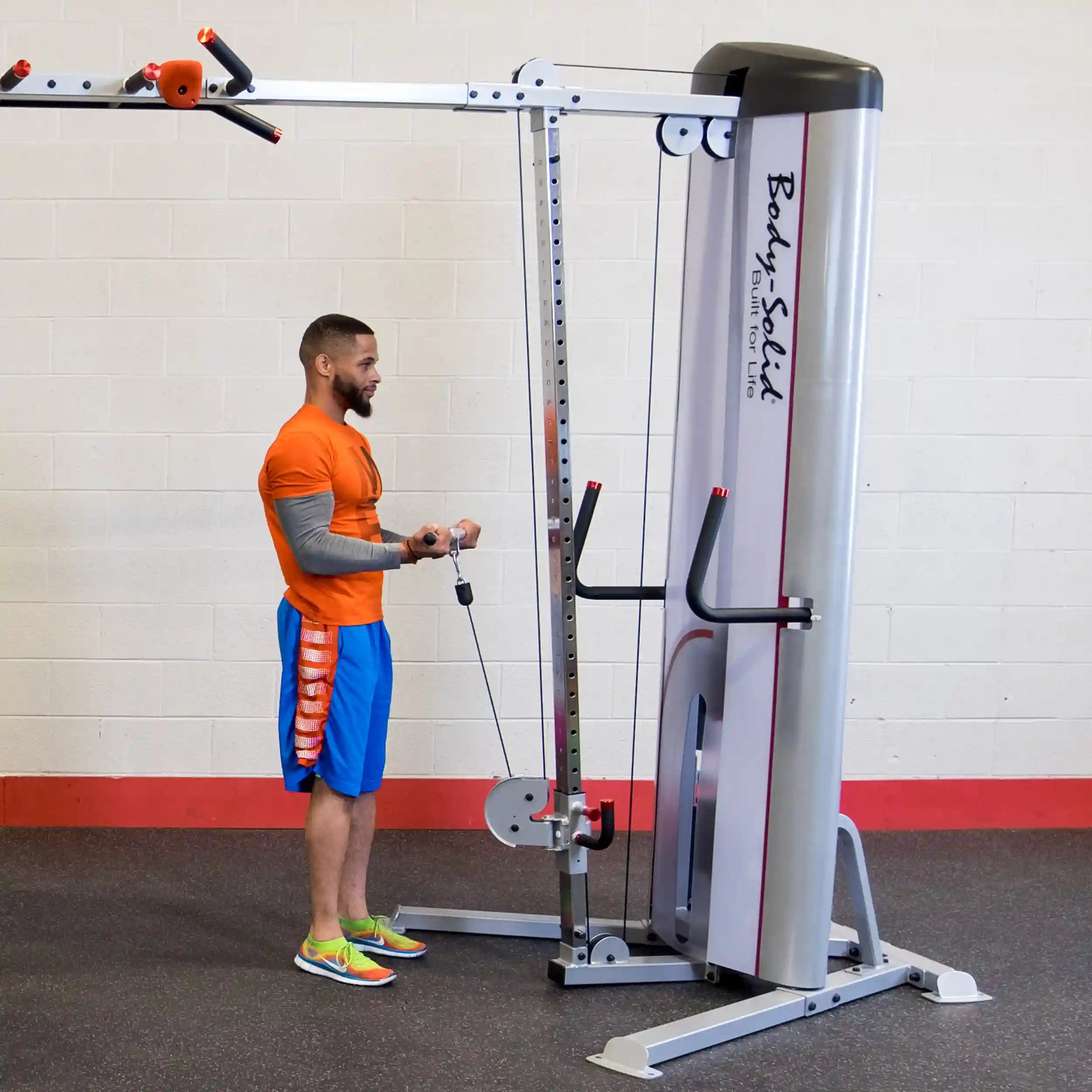 A man using the Body-Solid Pro ClubLine Series 2 Cable Crossover S2CCO in a gym setting, demonstrating a cable exercise.