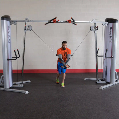A person performing a cable crossover exercise using the Body-Solid Pro ClubLine Series 2 Cable Crossover S2CCO in a gym setting.