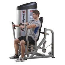A person using the Body-Solid Pro ClubLine Series 2 Chest Press Machine S2CP, demonstrating proper form while seated and pushing the handles forward.