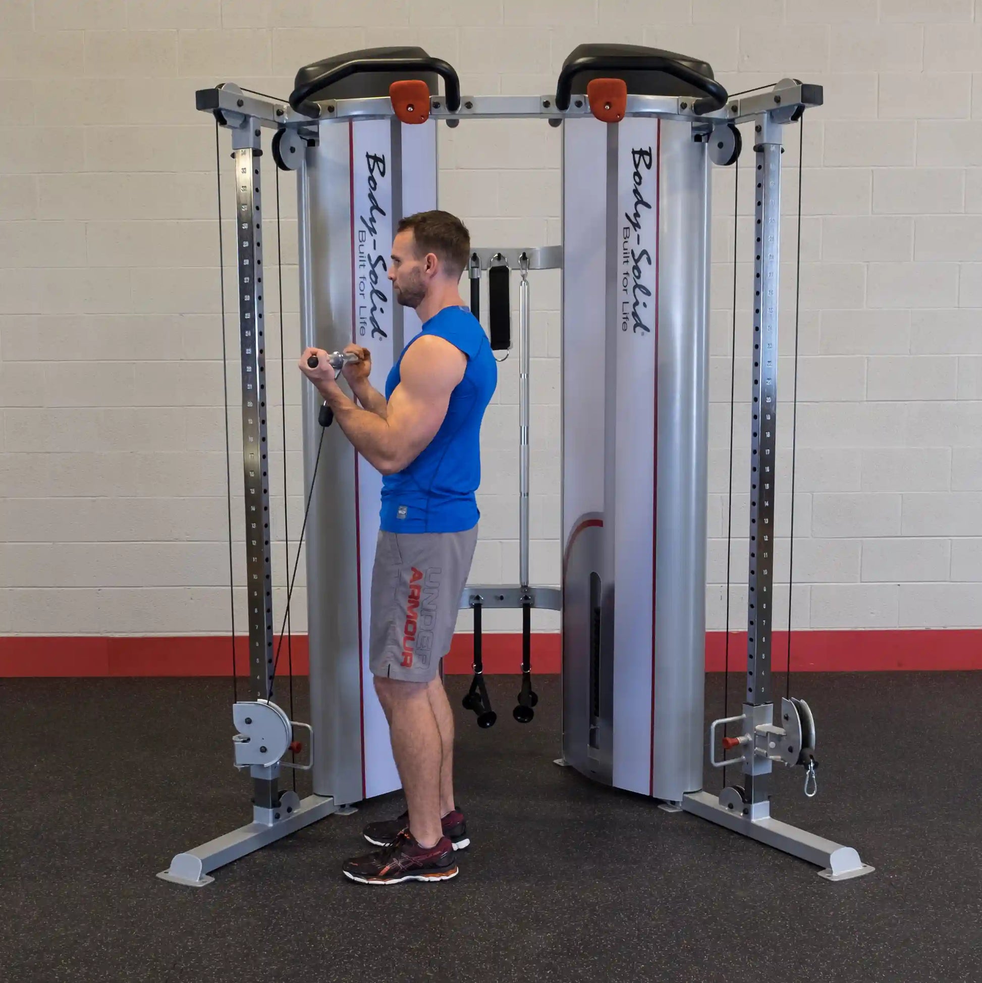 A man using the Body-Solid Pro ClubLine Series 2 Functional Trainer S2FT, performing an exercise with the cable machine in a gym setting.