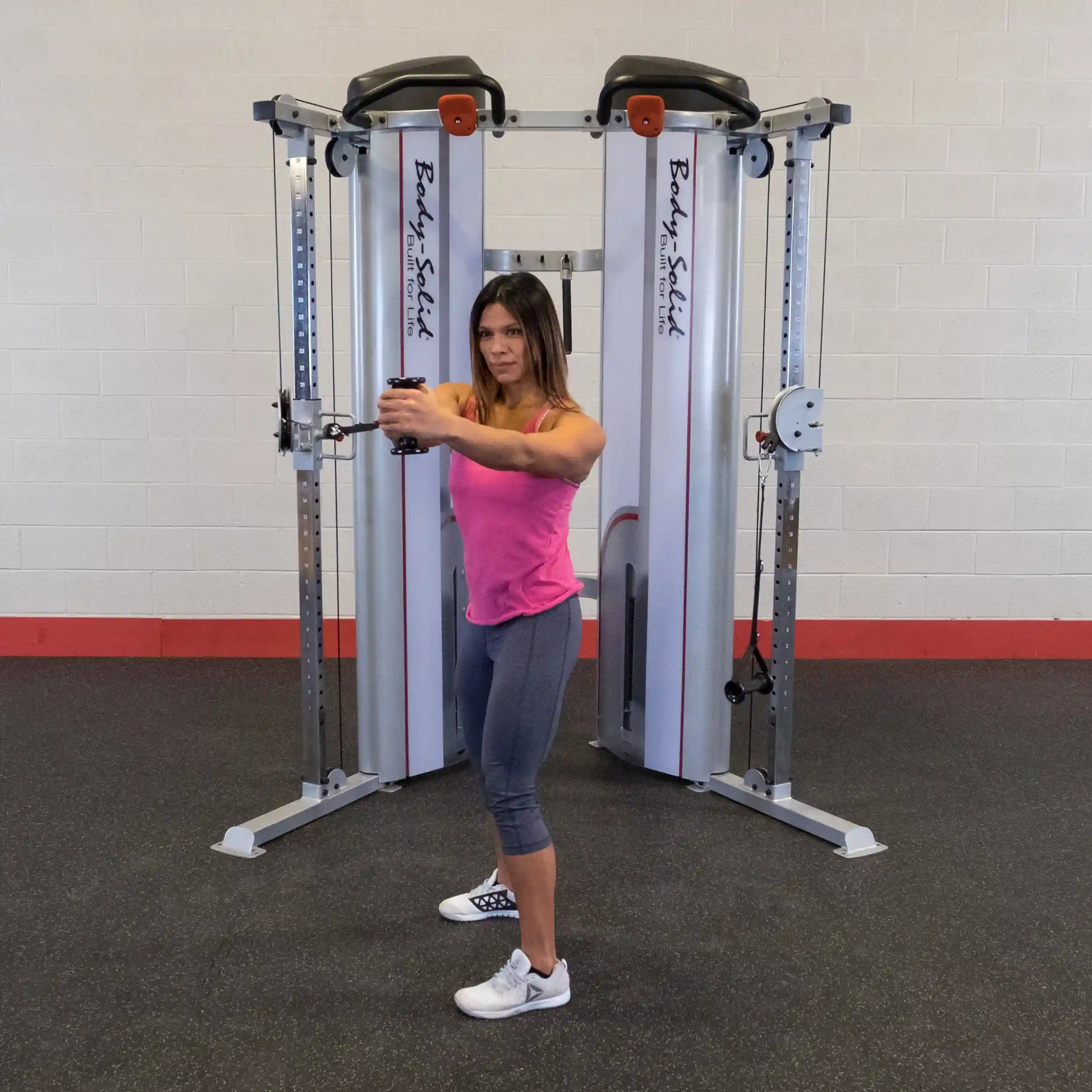 Person performing an exercise on the Body-Solid Pro ClubLine Series 2 Functional Trainer S2FT in a gym setting.
