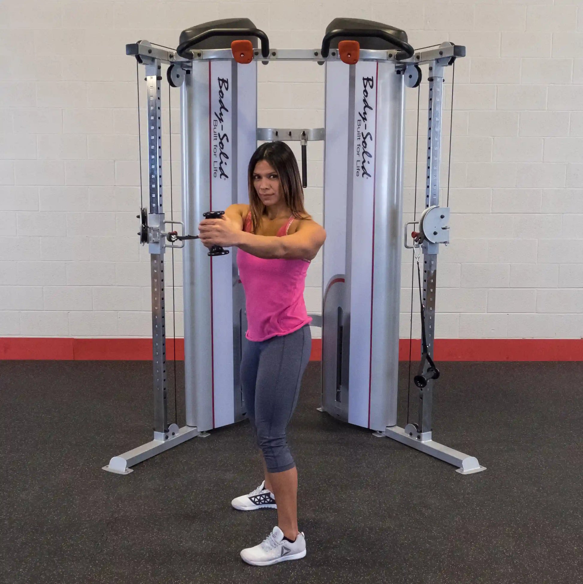 A woman performing an exercise with the Body-Solid Pro ClubLine Series 2 Functional Trainer S2FT, showcasing a fitness routine in a gym setting.
