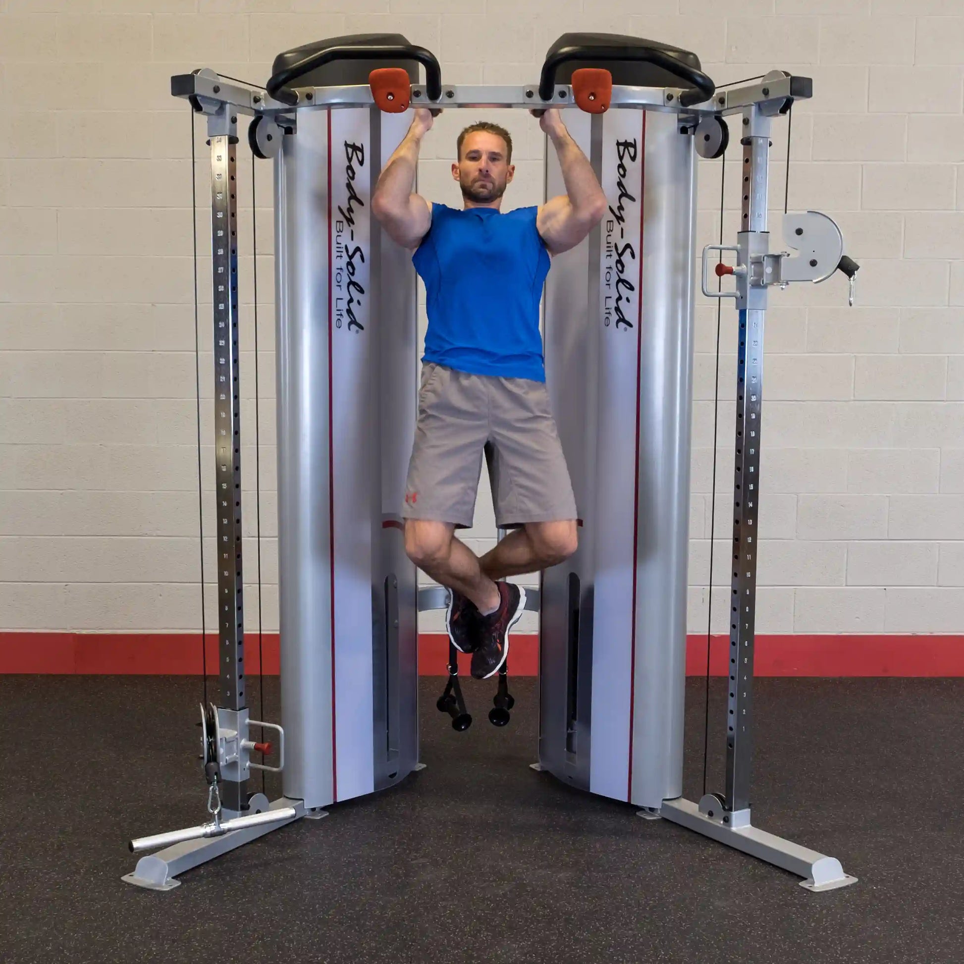 A person performing a pull-up on the Body-Solid Pro ClubLine Series 2 Functional Trainer S2FT, showcasing strength training equipment in a gym setting.