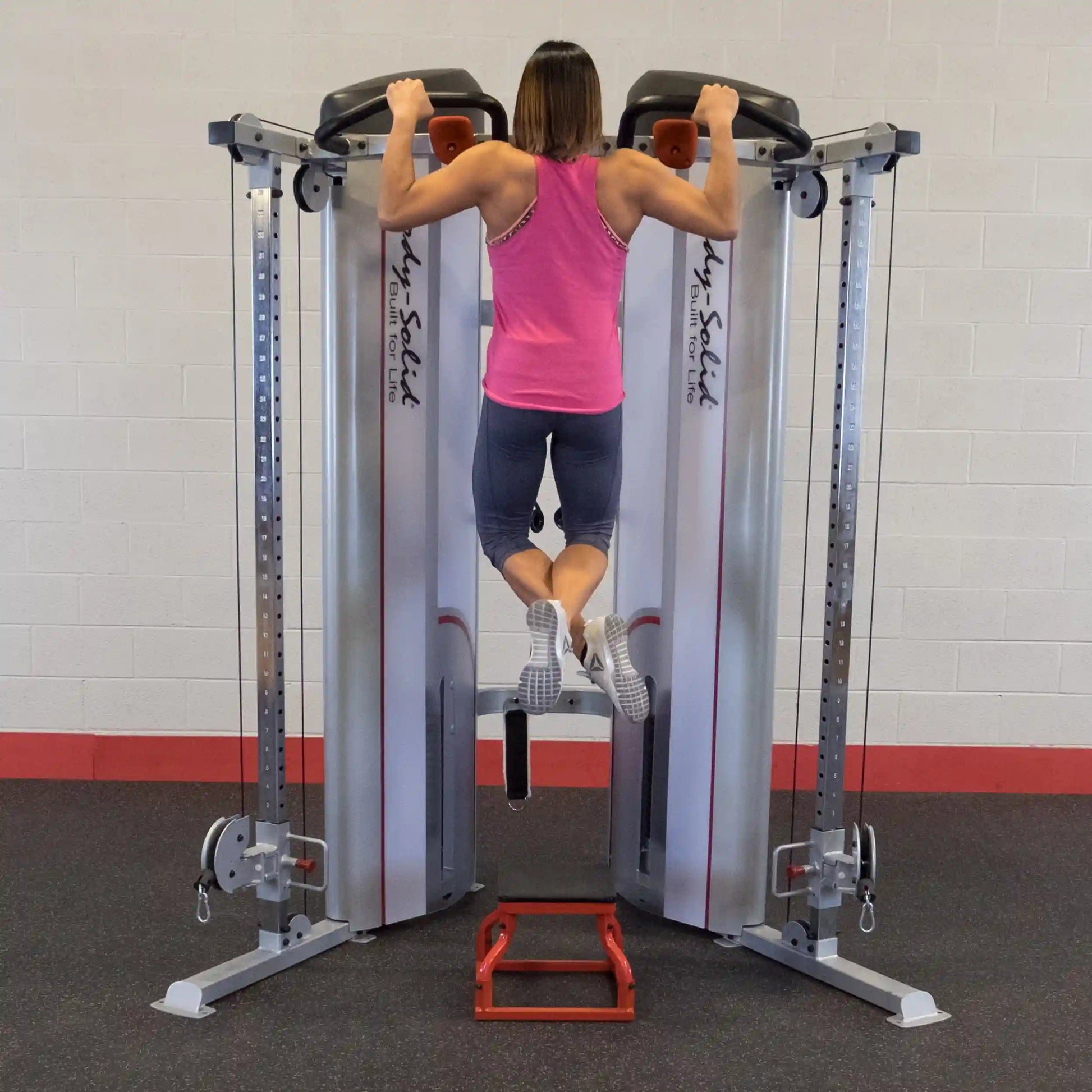 A person performing a pull-up on the Body-Solid Pro ClubLine Series 2 Functional Trainer S2FT in a gym setting.