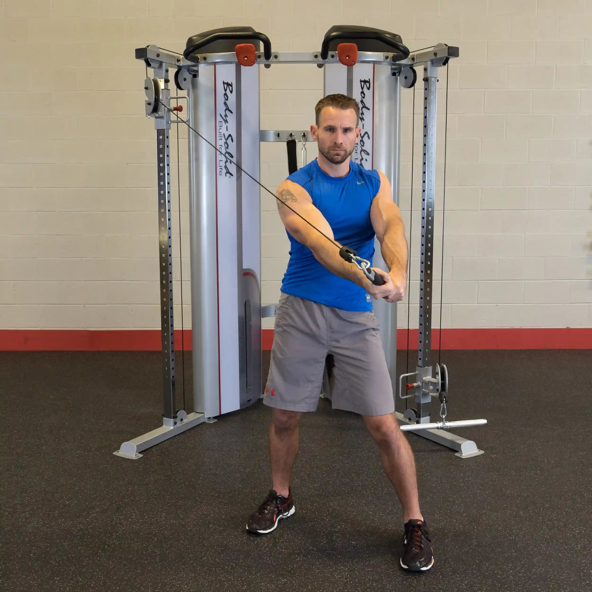 A person performing an exercise using the Body-Solid Pro ClubLine Series 2 Functional Trainer S2FT, showcasing strength training techniques in a gym setting.