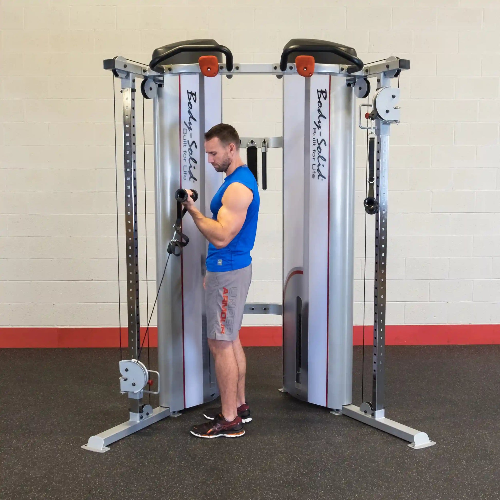 A person using the Body-Solid Pro ClubLine Series 2 Functional Trainer S2FT in a gym setting, demonstrating a workout with the cable machine.