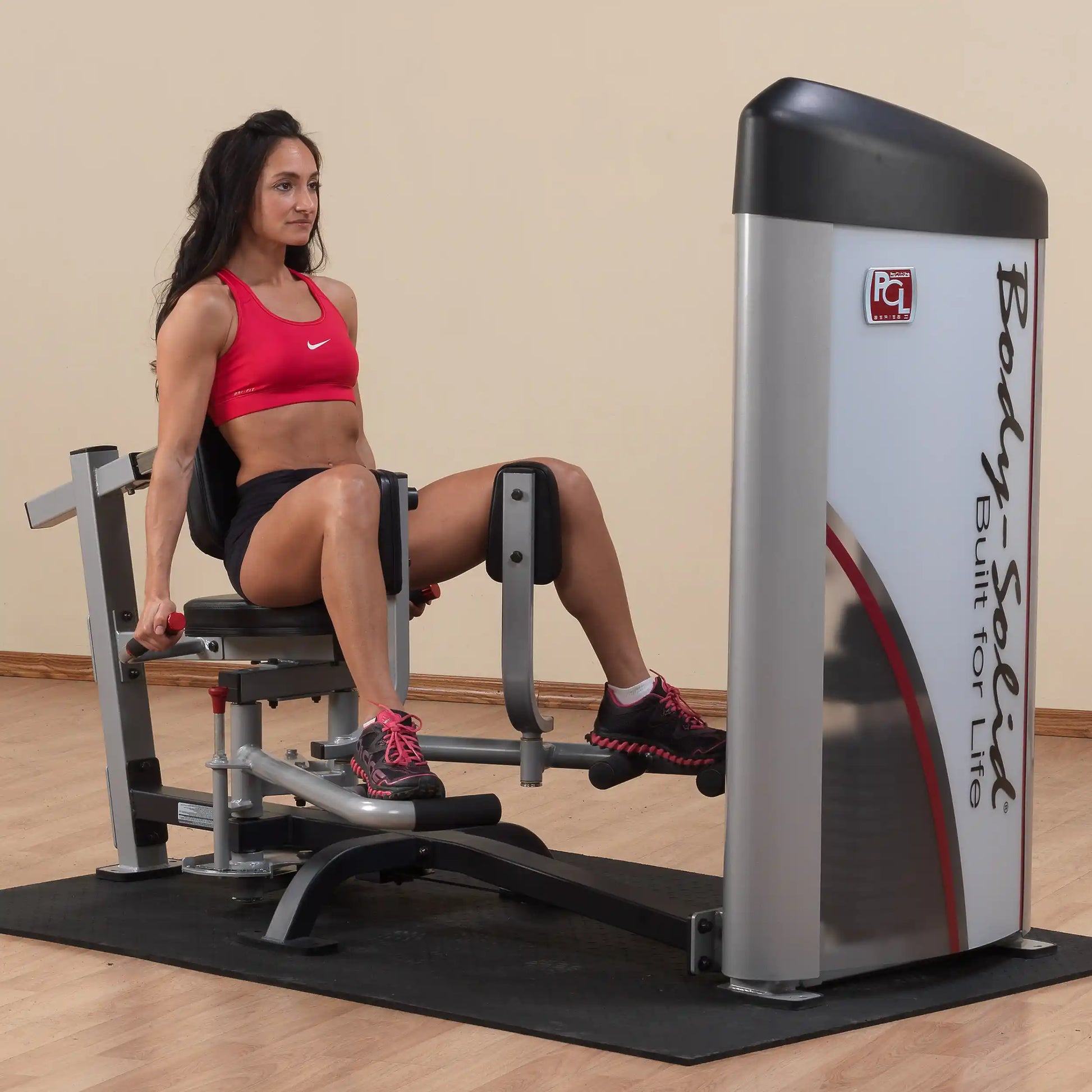 A woman using the Body-Solid Pro ClubLine Series 2 Inner & Outer Thigh Machine S2IOT in a gym setting, demonstrating thigh exercises with proper form.