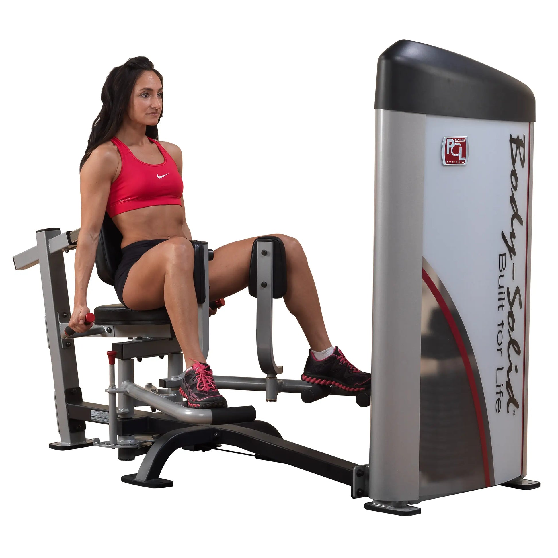 A woman demonstrating the Body-Solid Pro ClubLine Series 2 Inner & Outer Thigh Machine S2IOT, seated and engaged in a thigh workout.