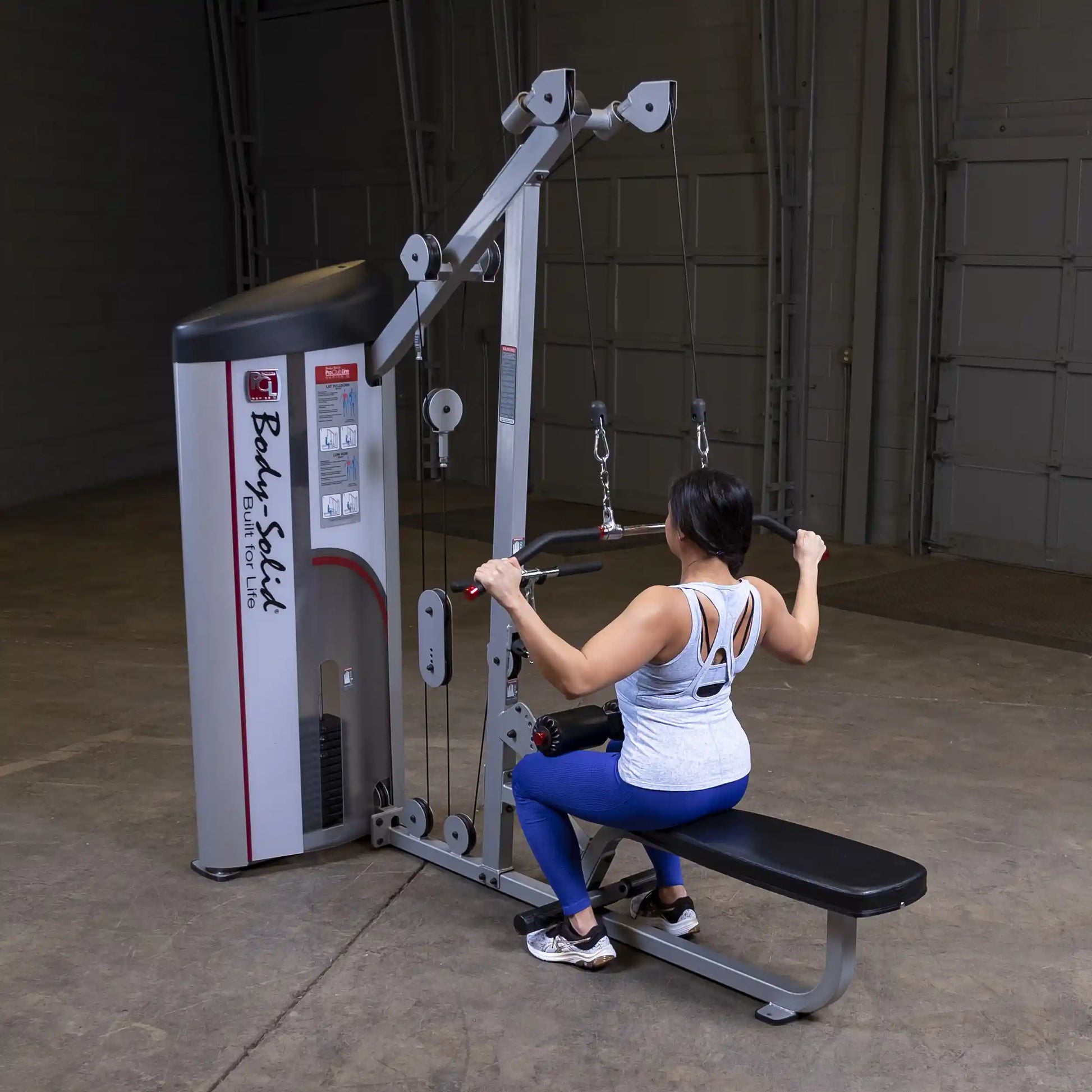 Body-Solid Pro ClubLine Series 2 Lat Pulldown & Seated Row Machine S2LAT with a person seated, performing a rowing exercise in a gym setting.