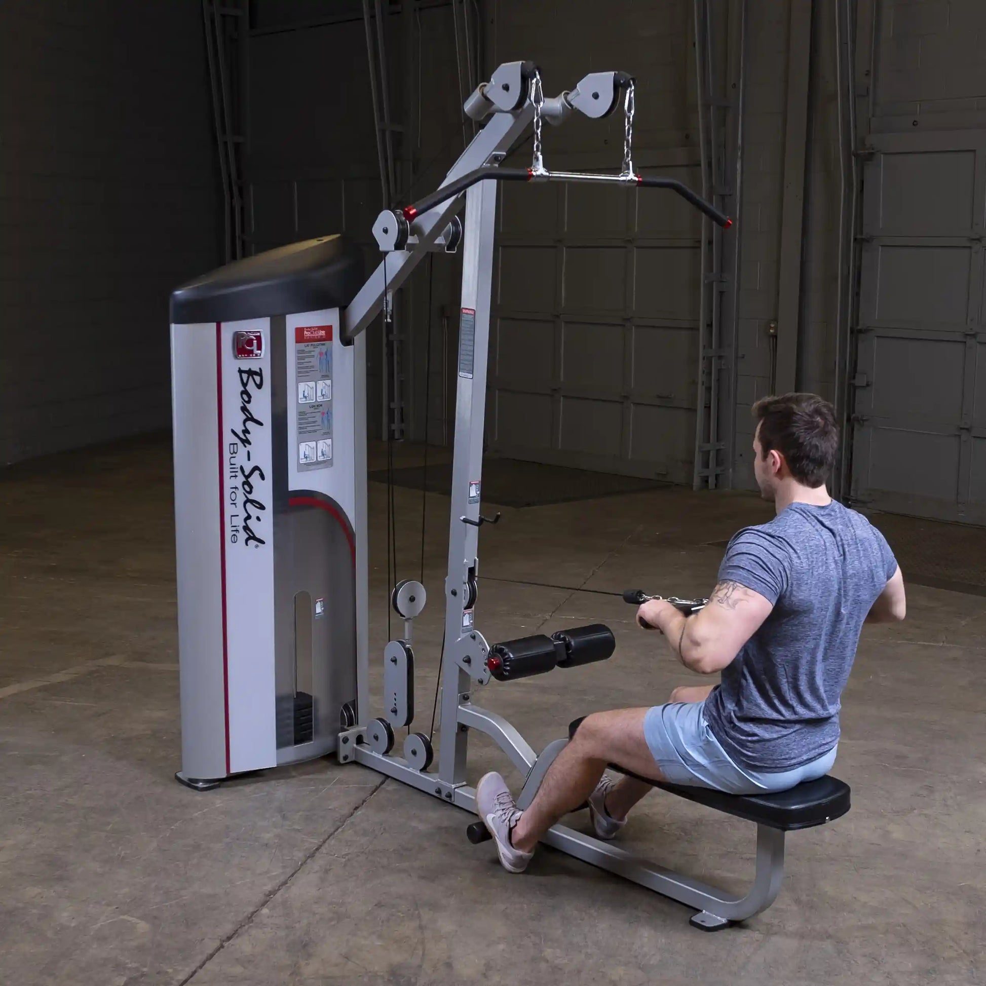 A person using the Body-Solid Pro ClubLine Series 2 Lat Pulldown & Seated Row Machine S2LAT in a spacious gym setting, demonstrating the seated row exercise.