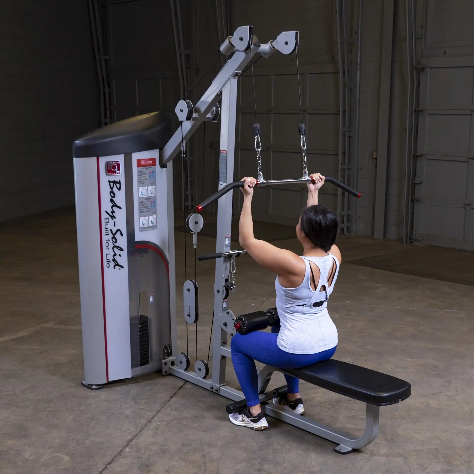 A person using the Body-Solid Pro ClubLine Series 2 Lat Pulldown & Seated Row Machine S2LAT in a gym setting, demonstrating a lat pulldown exercise.