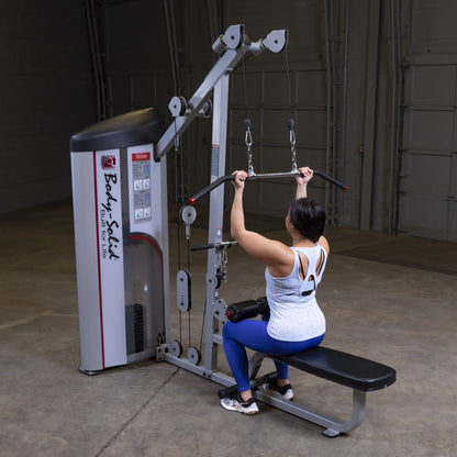 A person using the Body-Solid Pro ClubLine Series 2 Lat Pulldown & Seated Row Machine S2LAT in a gym setting, demonstrating a lat pulldown exercise.