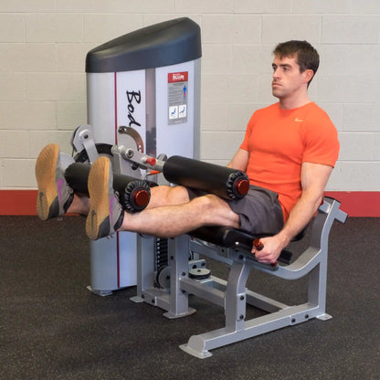A man using the Body-Solid Pro ClubLine Series 2 Leg Extension & Leg Curl Machine S2LEC in a gym setting, performing leg exercises with focused expression and proper form.