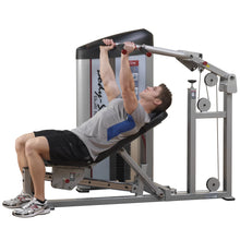 A man using the Body-Solid Pro ClubLine Series 2 Multi-Press Machine S2MP in a gym, demonstrating a seated press exercise.