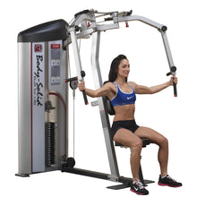 A woman using the Body-Solid Pro ClubLine Series 2 Pec Fly & Rear Delt Machine S2PEC, seated and performing a chest fly exercise in a gym setting.