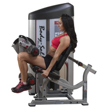 A woman using the Body-Solid Pro ClubLine Series 2 Seated Leg Curl Machine S2SLC, performing leg curls with focused expression and proper form.