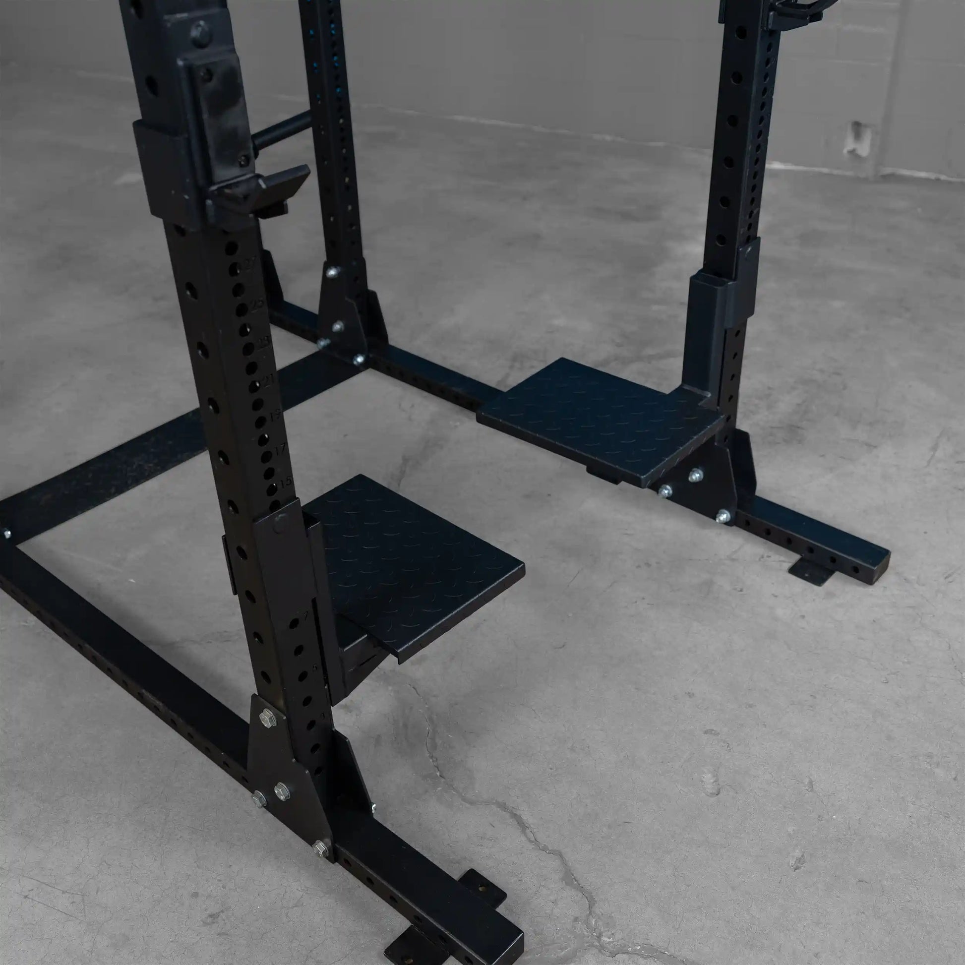 Close-up view of the Body-Solid Pro ClubLine Spotter Platforms SPRSP, featuring sturdy black platforms designed for weightlifting support.