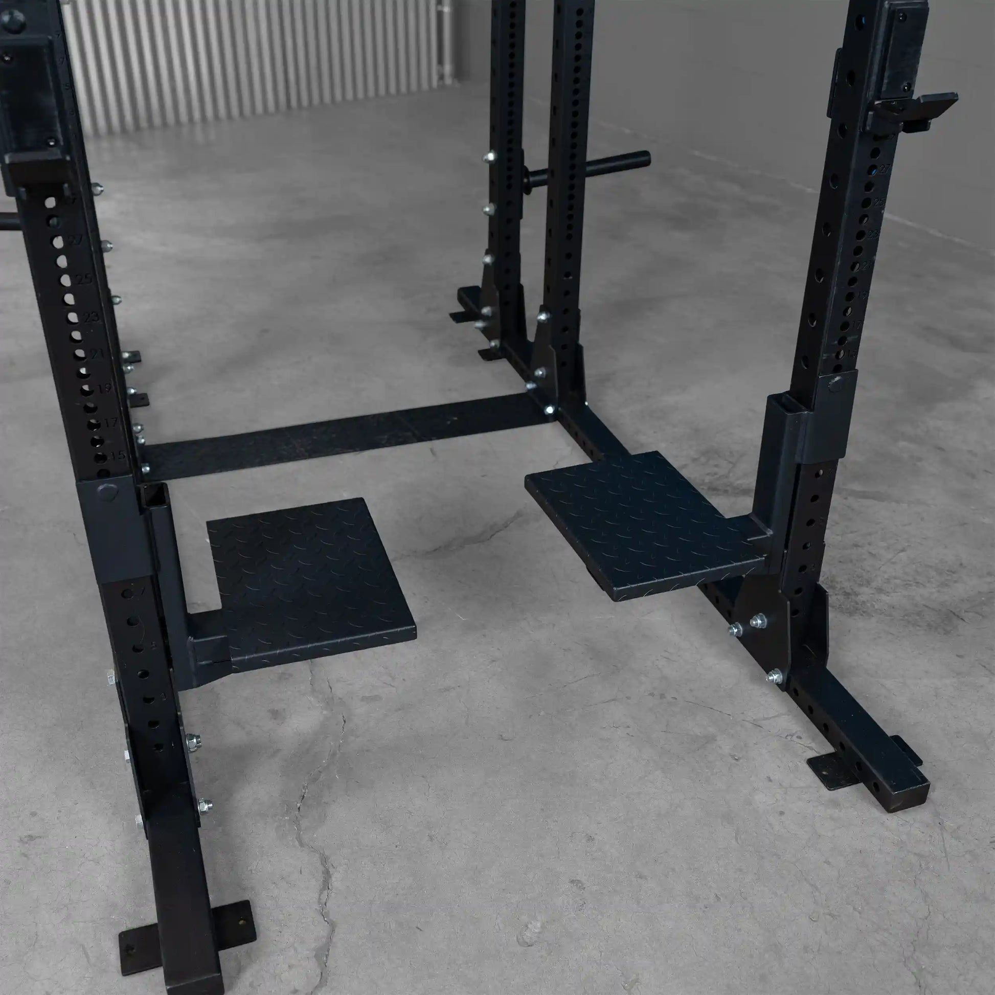 Body-Solid Pro ClubLine Spotter Platforms SPRSP mounted on a weight training rack with a solid black finish and textured non-slip surfaces for stability during workouts.