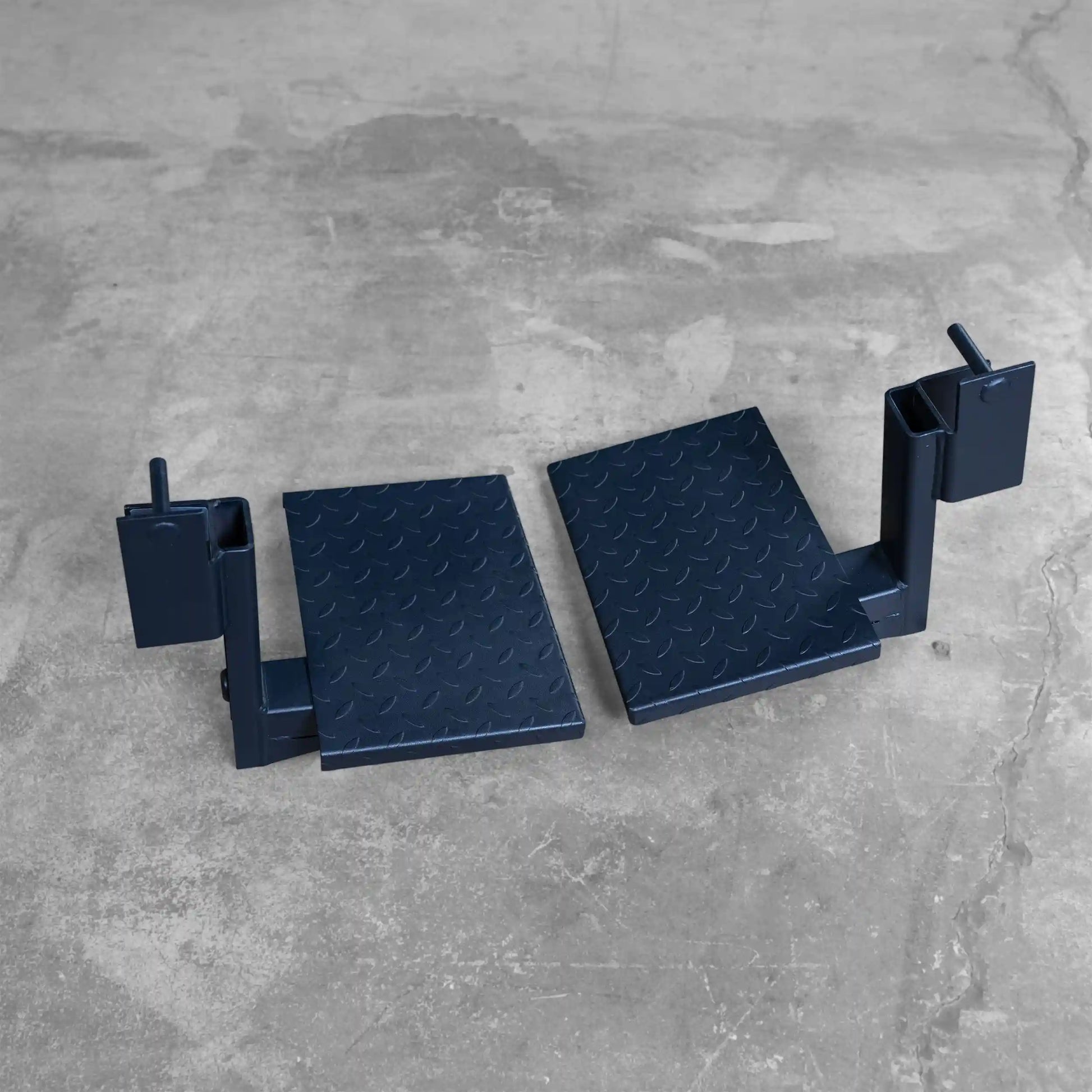 Body-Solid Pro ClubLine Spotter Platforms SPRSP displayed on a concrete surface, featuring two sturdy black platforms with a textured surface.